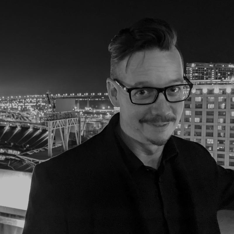 Christopher Land, wearing glasses and a dark shirt